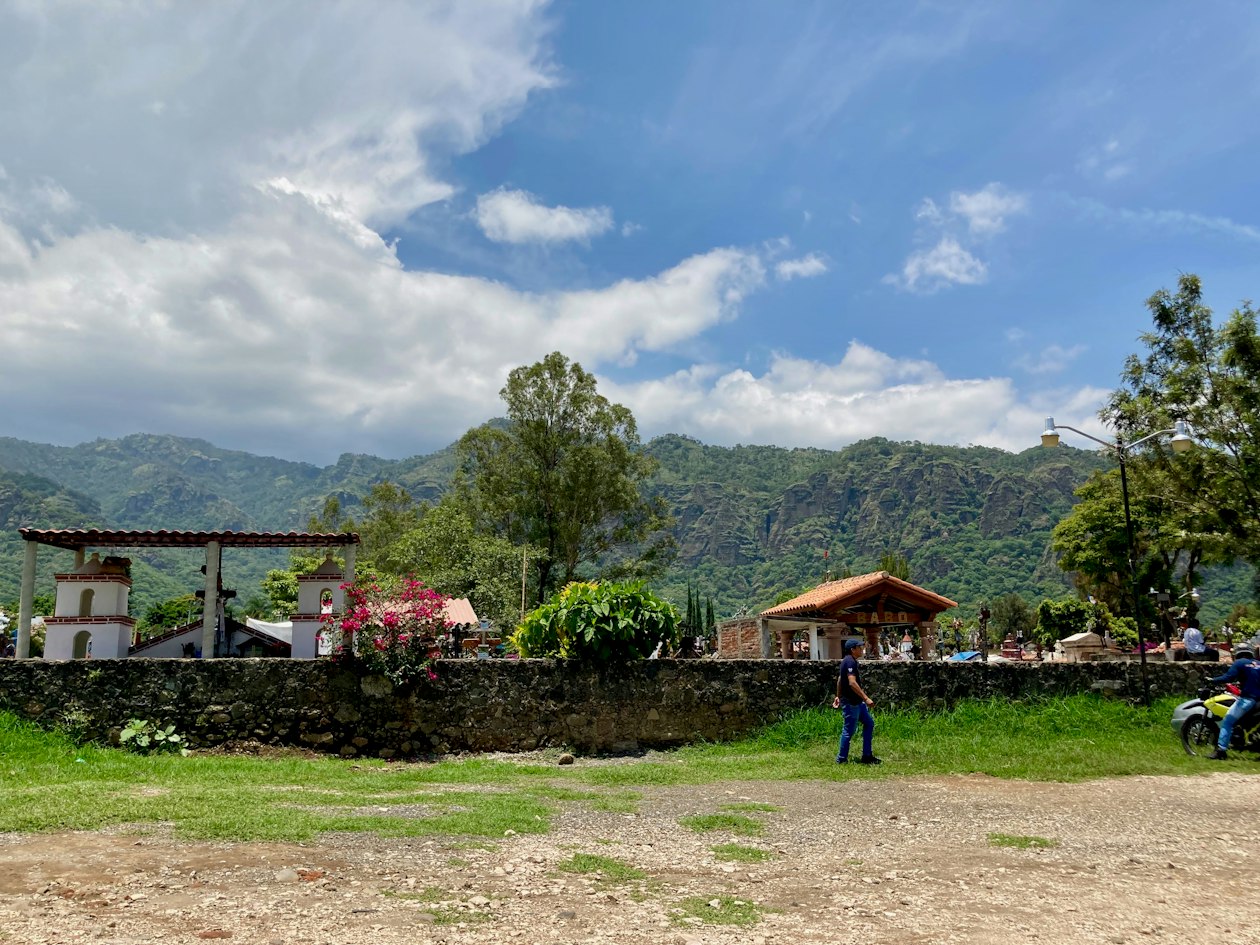 Collines vertes et falaises derrière un mur de pierre et une petite chapelle près de Tepoztlán à la saison des pluies