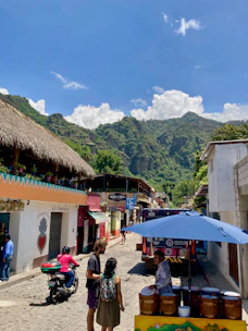 a group of people walking down a street next to buildings