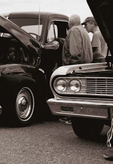 Members of Castries Rétro Sport sharing stories next to their beloved vintage vehicles.