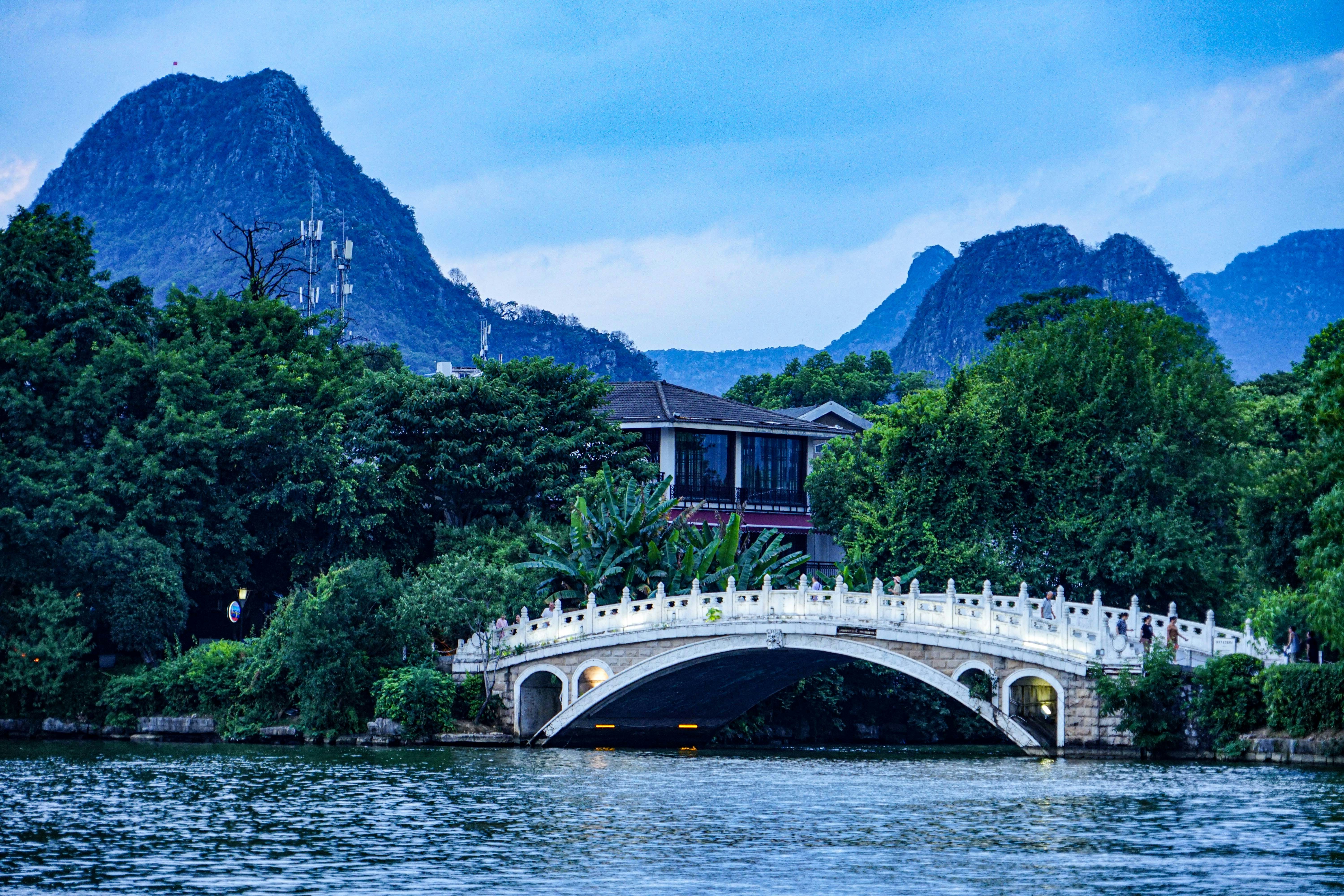 a bridge over a body of water with mountains in the background