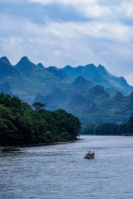 A group enjoying a peaceful river rafting experience, laughter and splashes under towering trees.