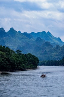 Volunteers guiding pilgrims along the riverbank with calm blue skies and green surroundings