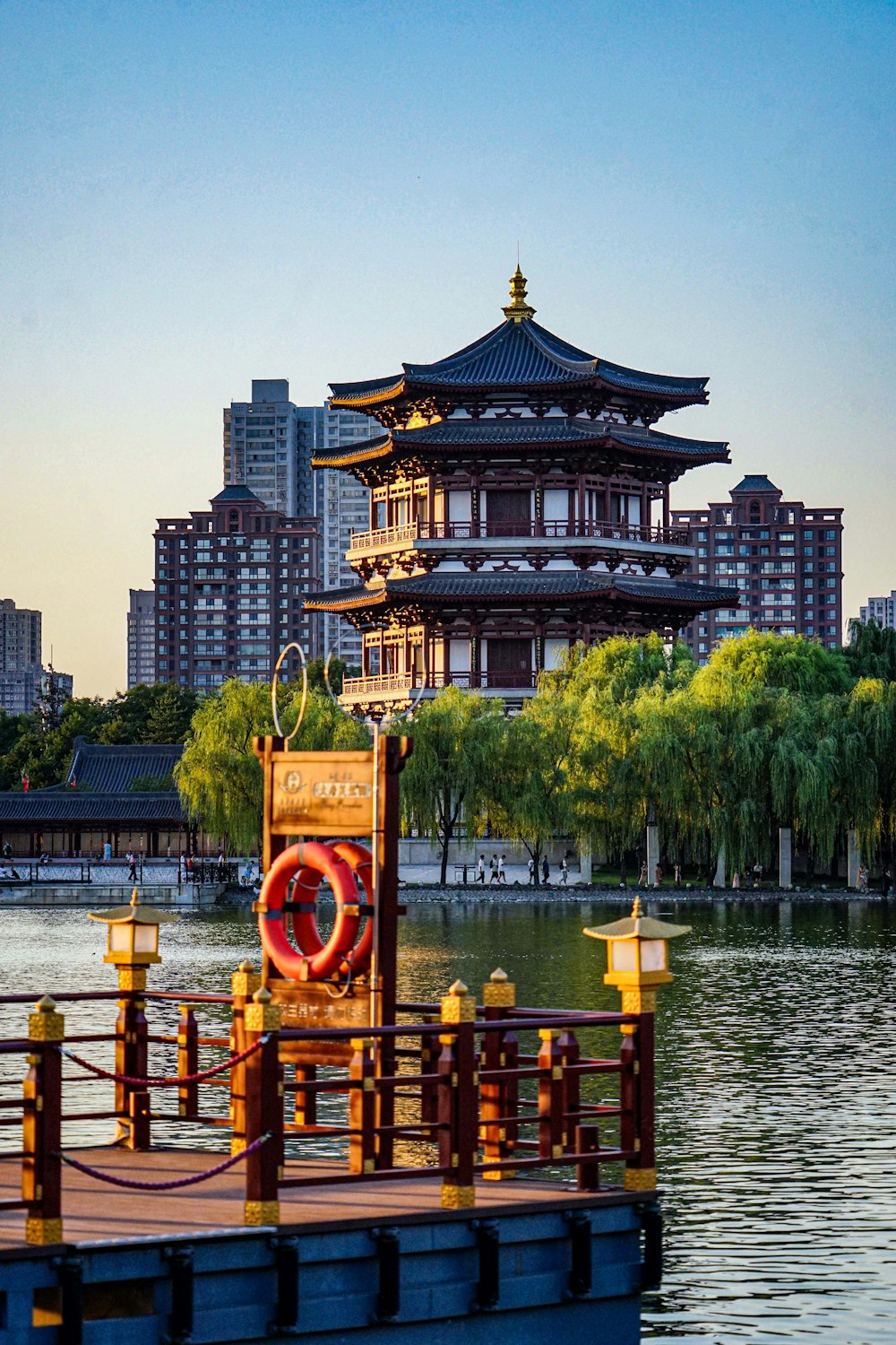 a boat floating on top of a lake next to a tall building