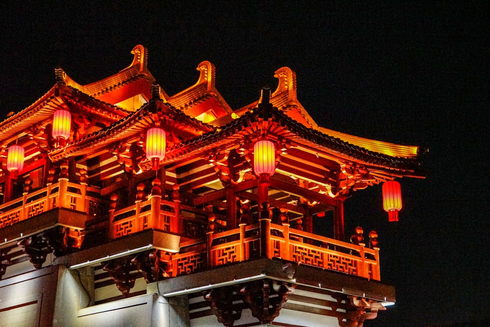 a tall building with red lanterns on top of it