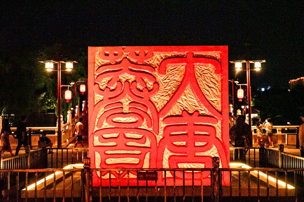 Una gran escultura roja se ilumina por la noche