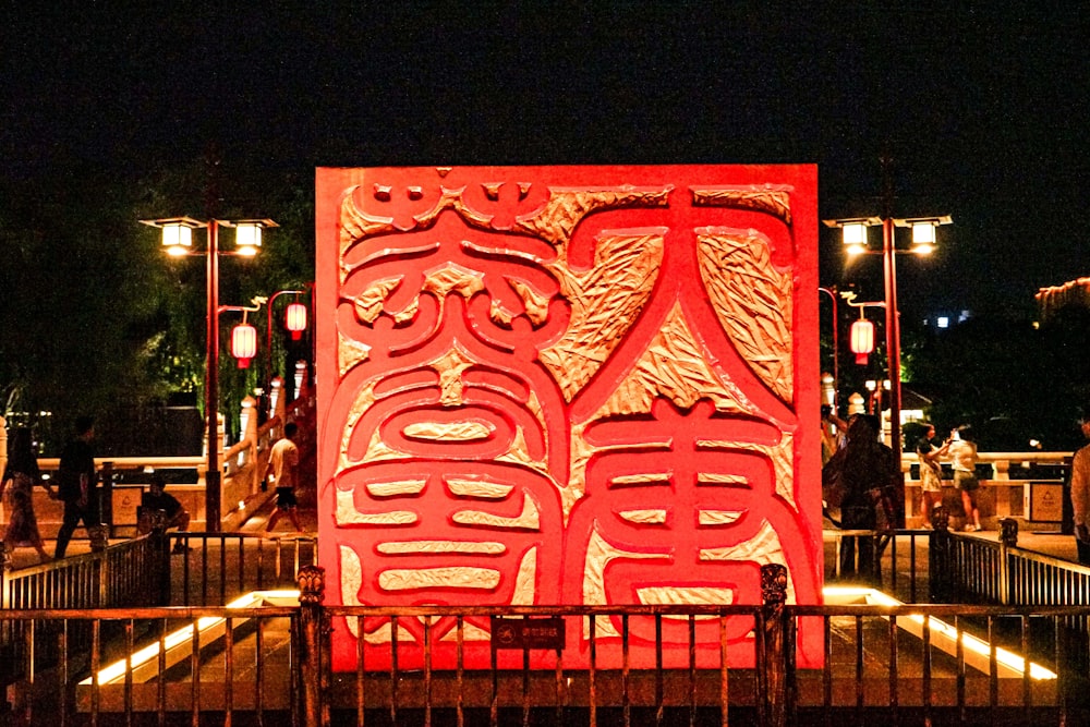 a large red sculpture is lit up at night