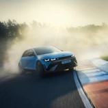 High-resolution photo of a sleek car drifting sharply on a race track under bright sunlight.