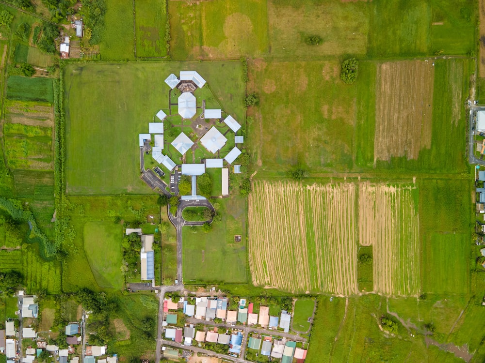 an aerial view of a green field with buildings