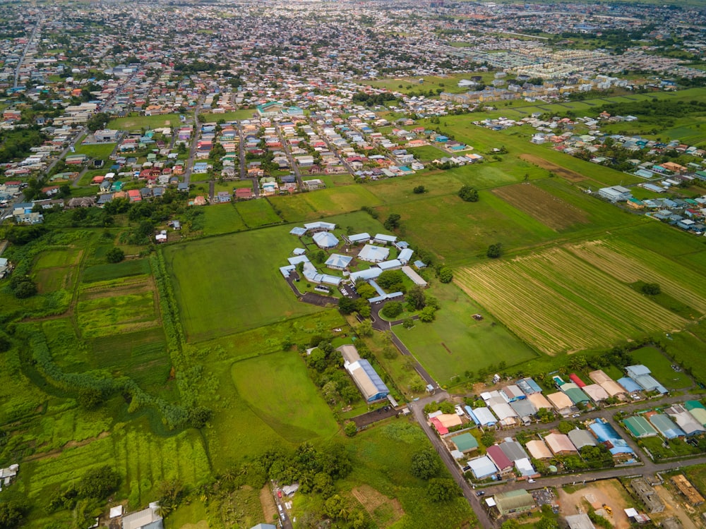 an aerial view of a city with lots of green grass