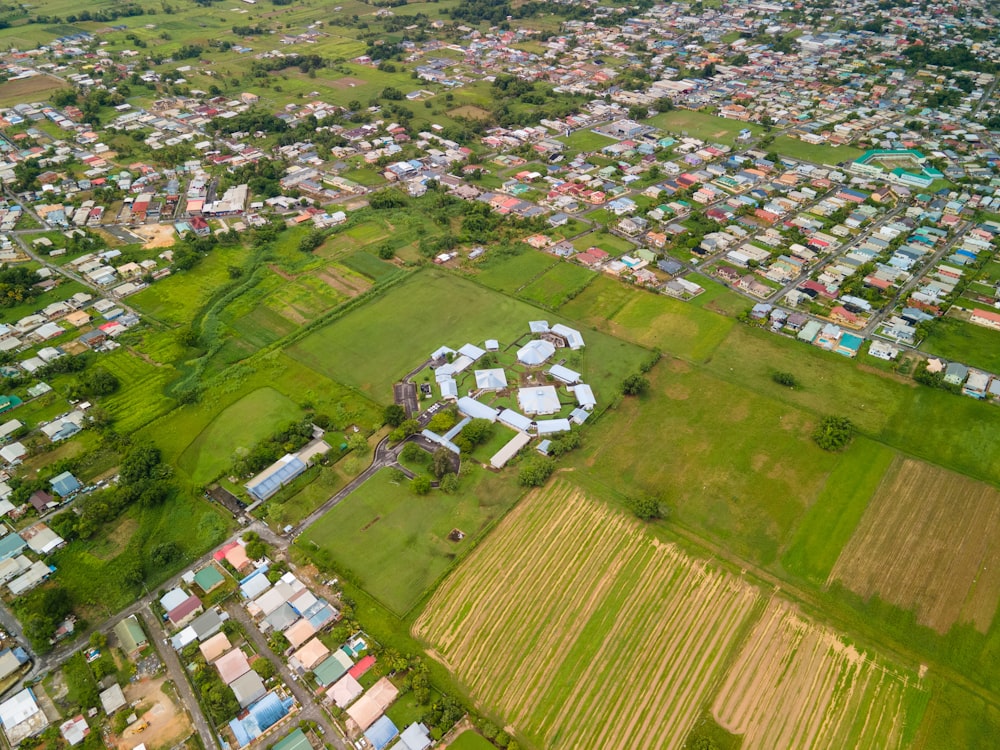 an aerial view of a city with lots of green grass