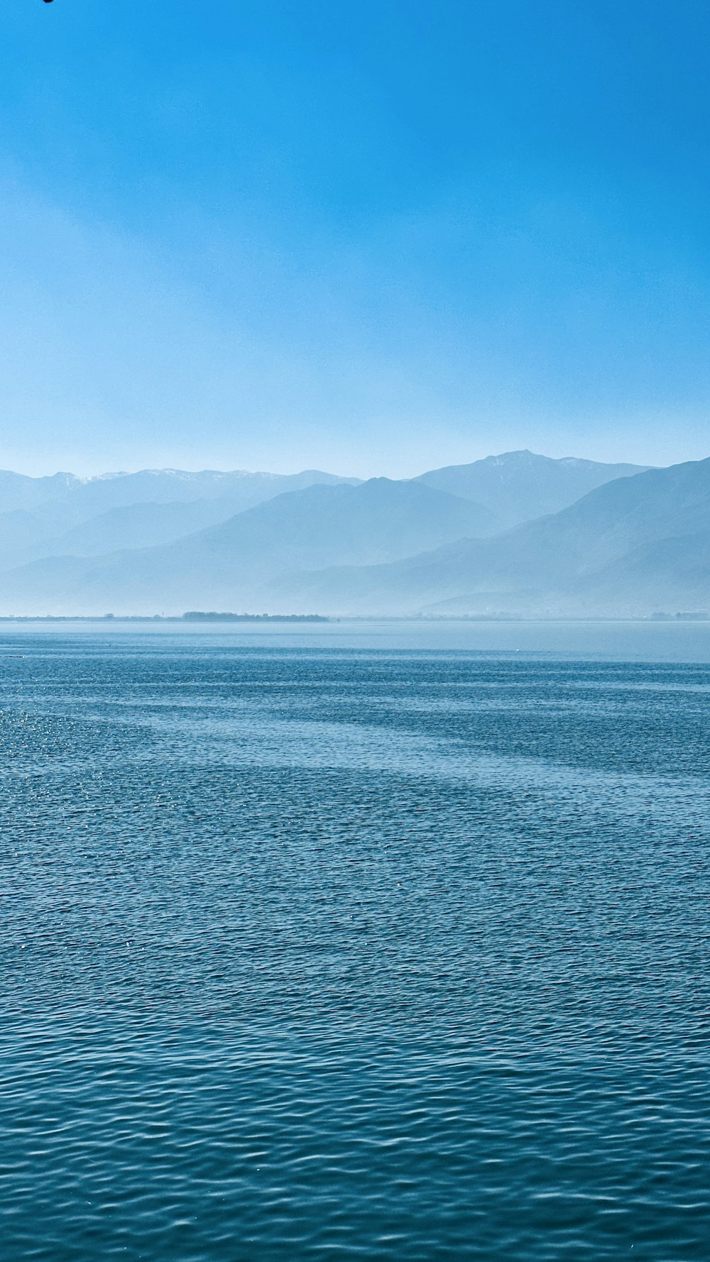 a large body of water with mountains in the background