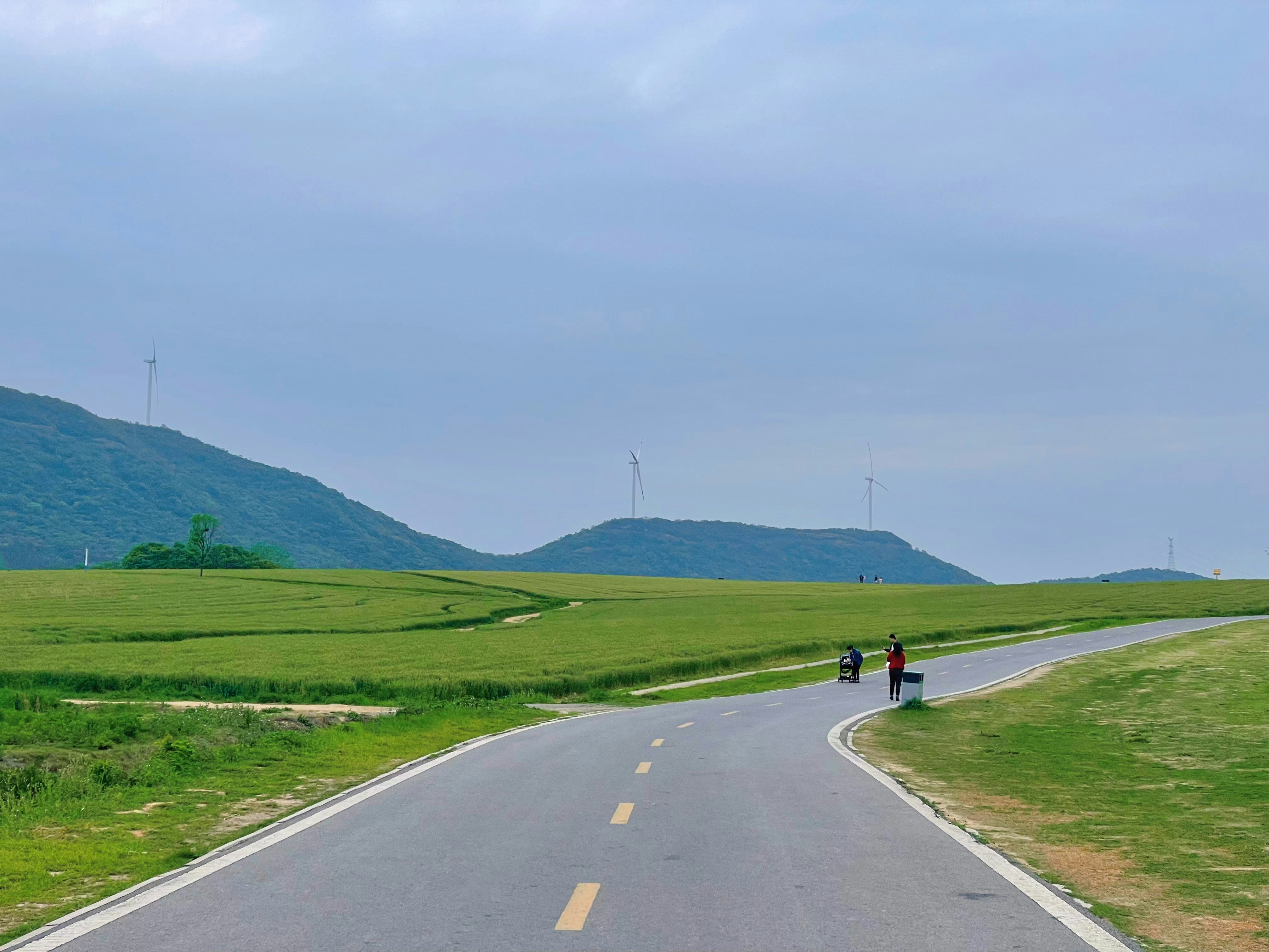 two people walking down the middle of a road