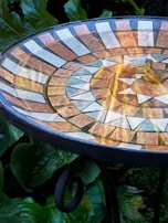 A close-up of intricate mosaic patterns on a dining table.