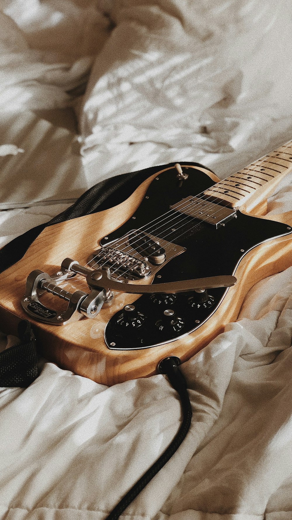 an electric guitar is laying on a bed