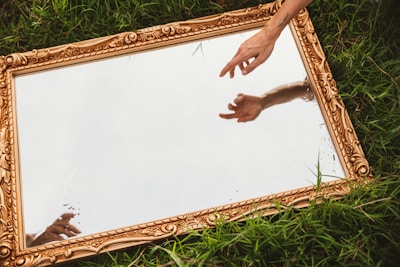 a person reaching out their hand to touch a mirror