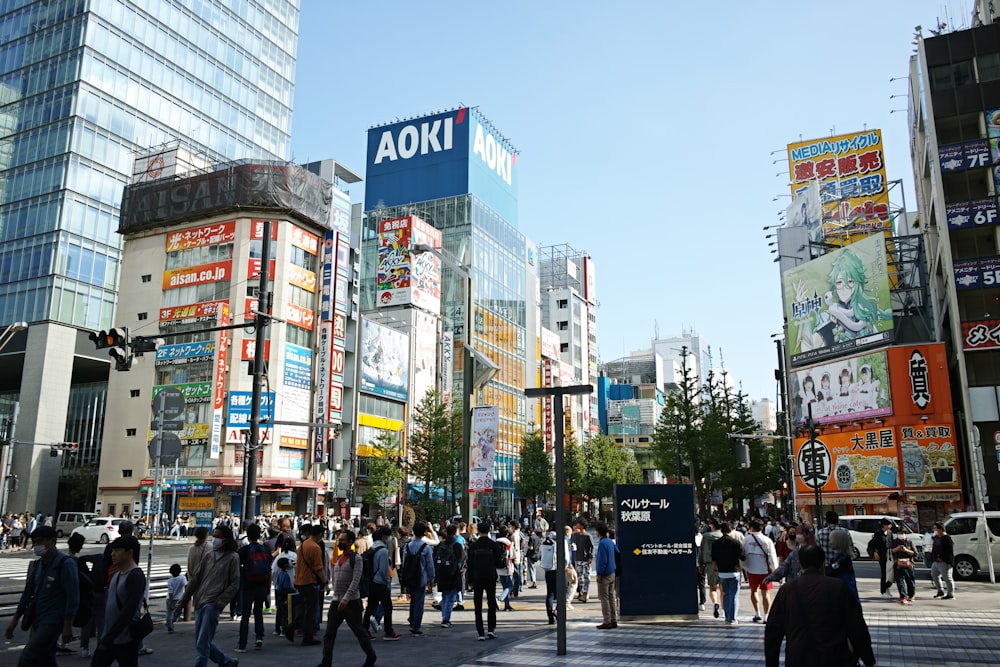 a group of people walking down a street next to tall buildings