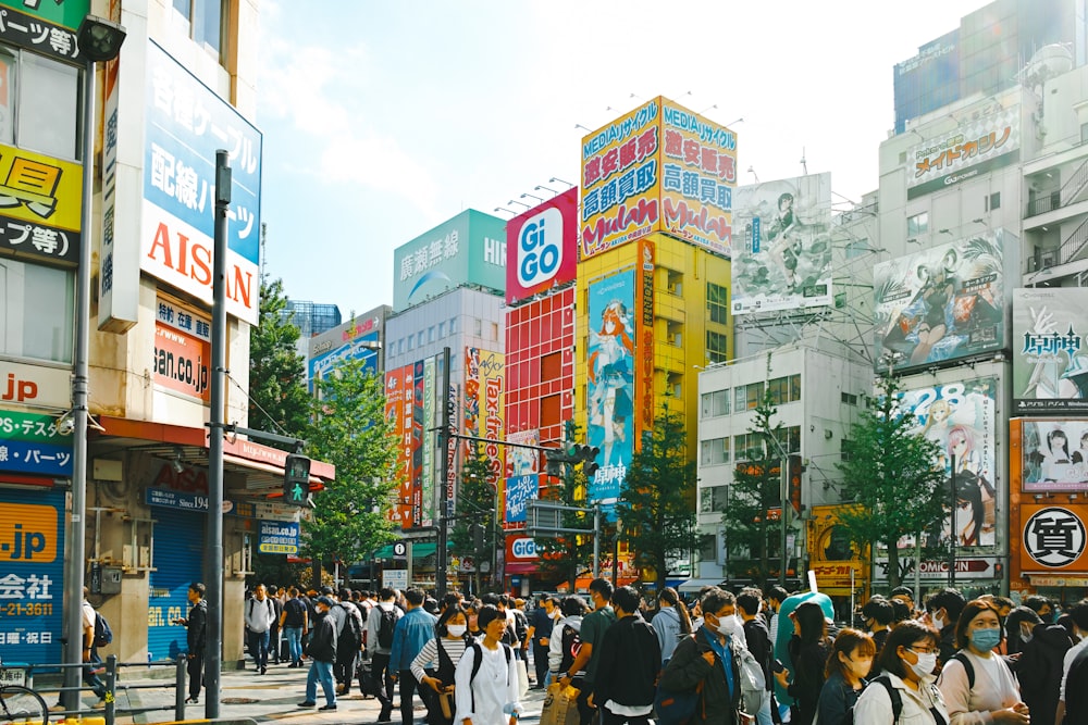 a group of people walking down a street next to tall buildings