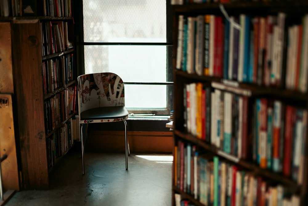 a chair sitting in front of a bookshelf filled with books