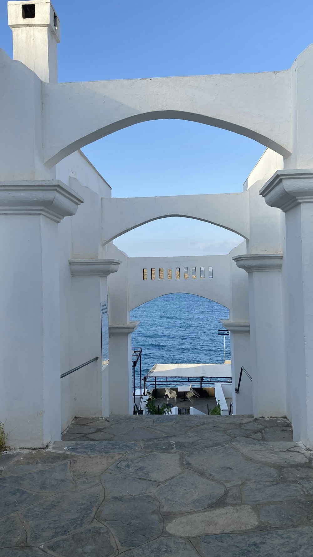 an archway leading to the ocean on a sunny day