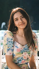 a woman sitting on a white chair next to a table
