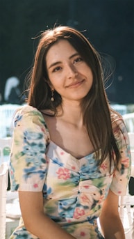 a woman sitting on a white chair next to a table