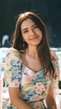 a woman sitting on a white chair next to a table