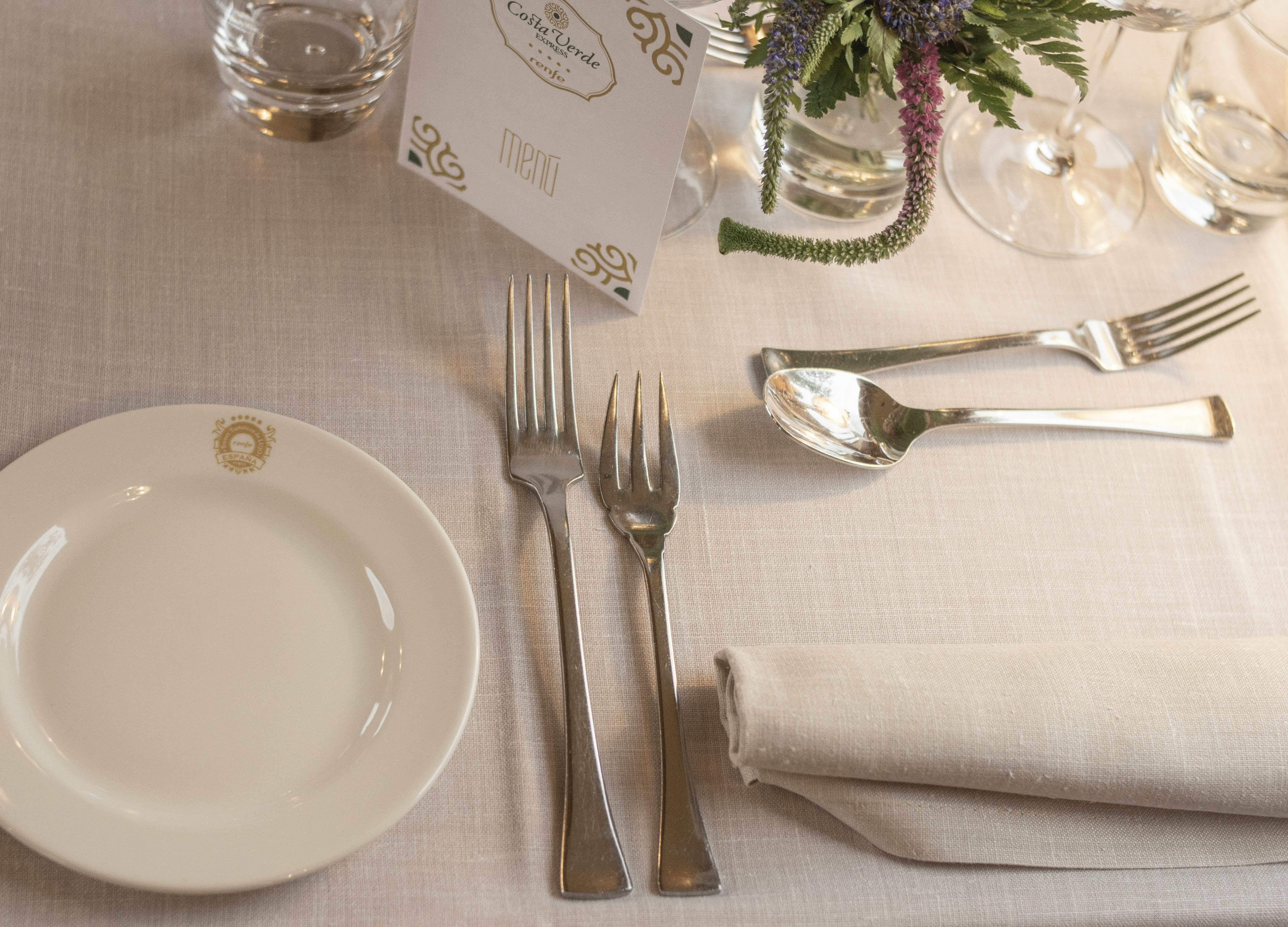 a table set for a formal dinner with silverware, Restaurante a bordo del tren turístico, antiguo, de lujo de Renfe - Costa Verde Express