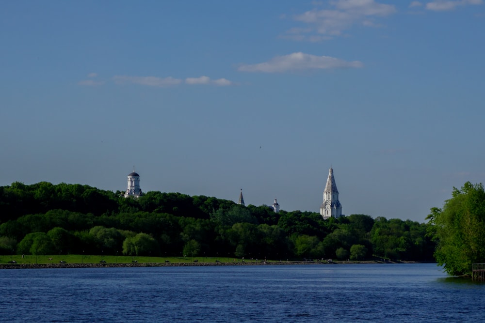 a large body of water with trees on a hill in the background