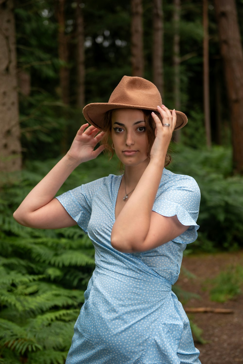 Una mujer con un vestido azul y un sombrero marrón