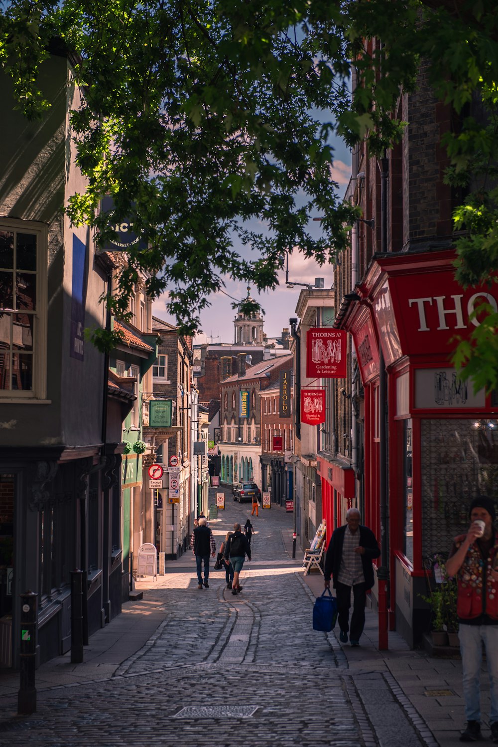 a group of people walking down a cobblestone street