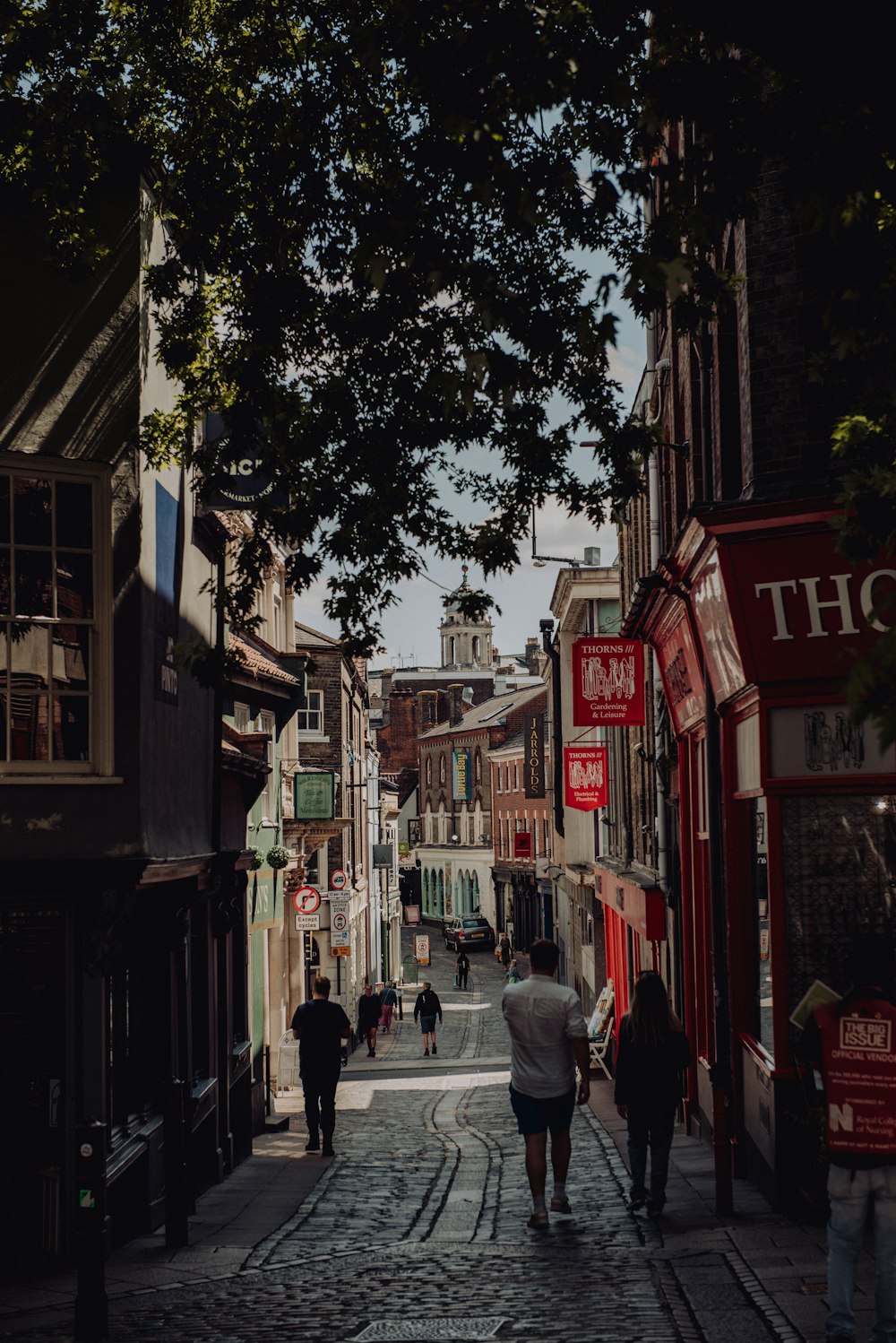 a group of people walking down a cobblestone street