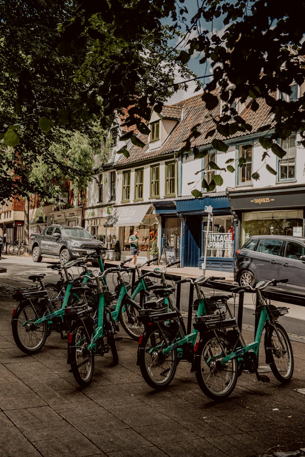 eine Gruppe von Fahrrädern, die nebeneinander auf einem Bürgersteig geparkt sind