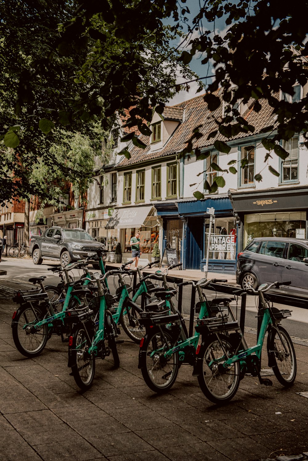 a group of bikes parked next to each other on a sidewalk