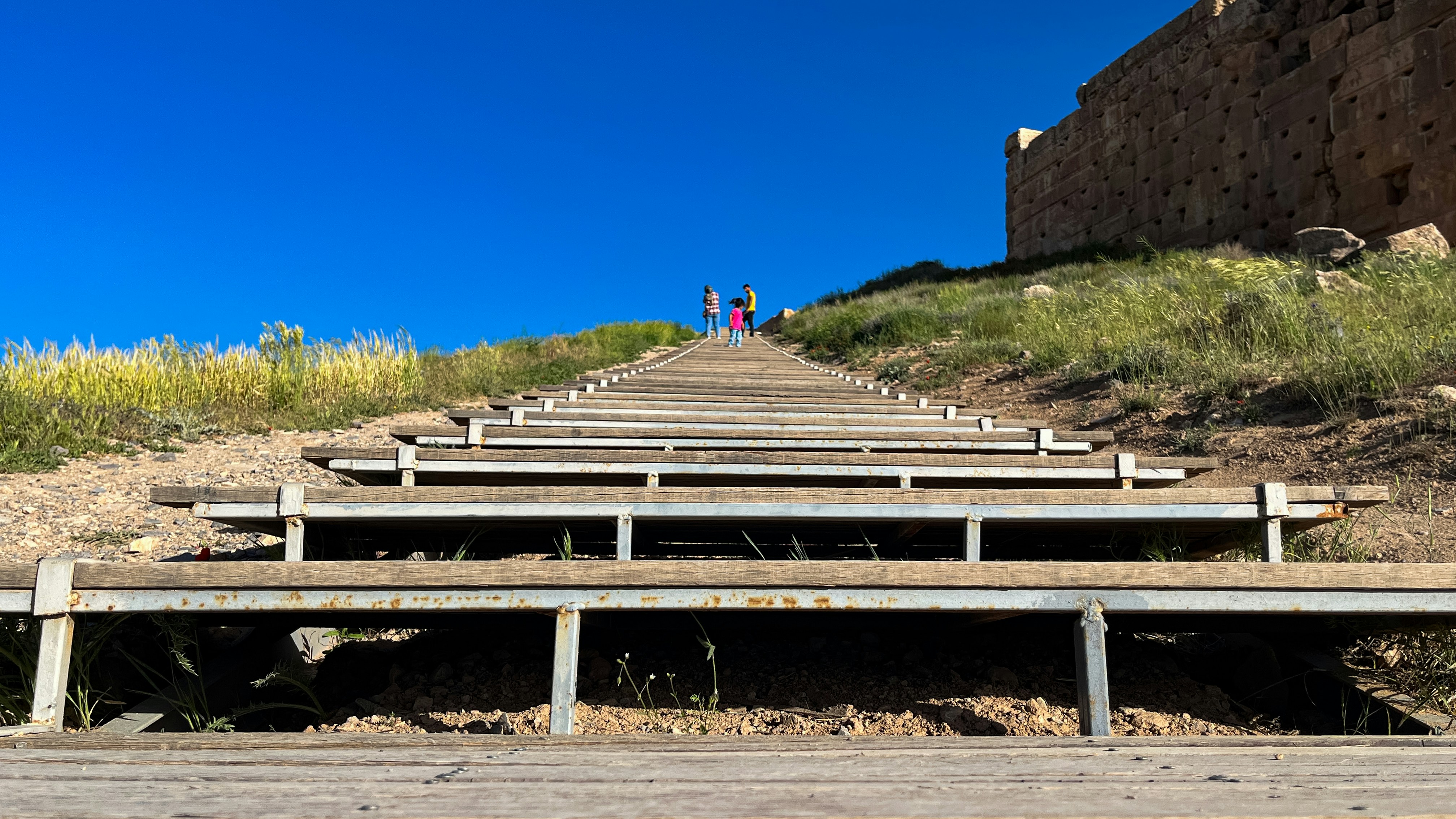 a group of people standing on top of a wooden ramp