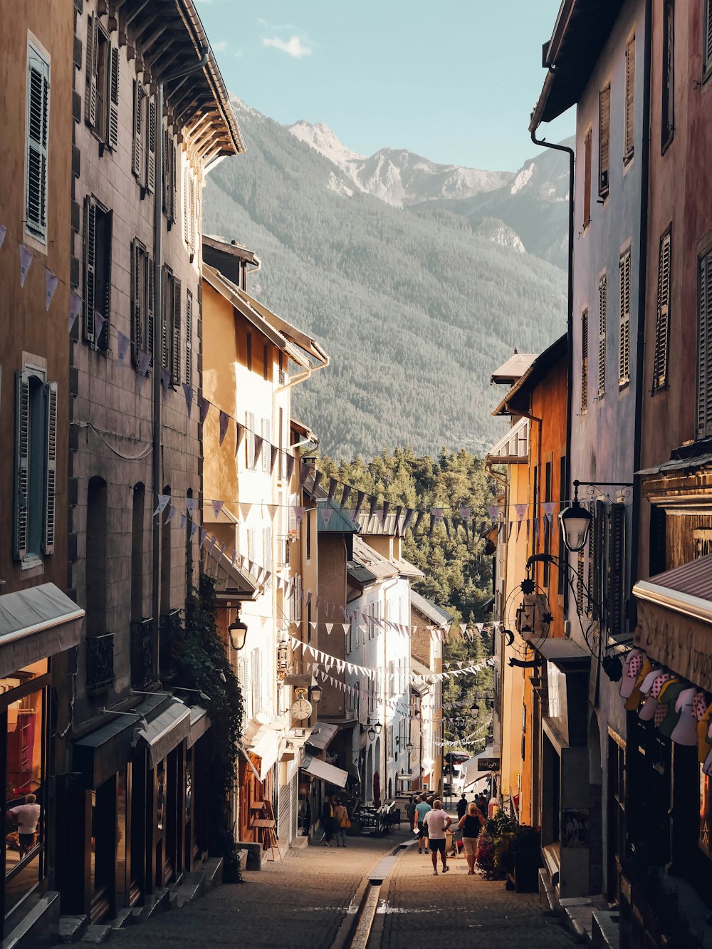 a narrow street with people walking down it