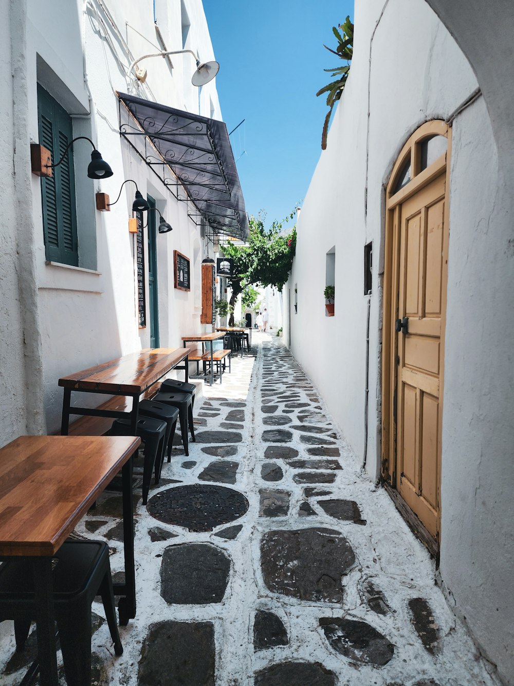 a narrow alley with tables and benches on either side