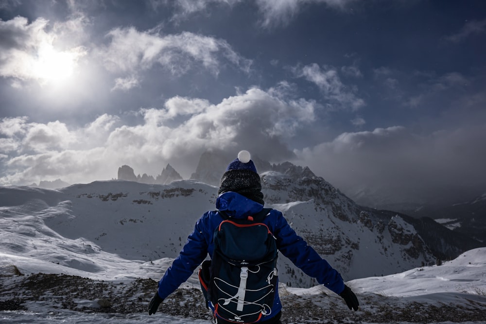 uma pessoa com uma mochila em uma montanha nevada