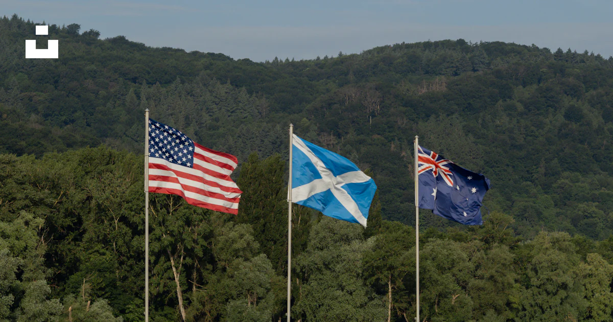 A group of three flags flying next to a river photo – Free Image on ...