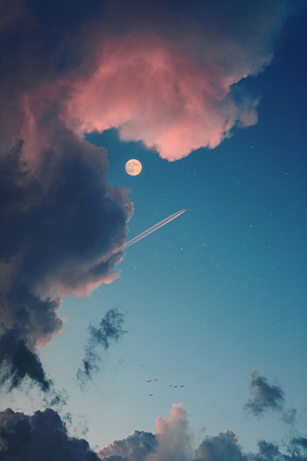 a plane flying through a cloudy blue sky