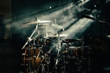 Dynamic shot of the full drum kit surrounded by fog and colored lights.