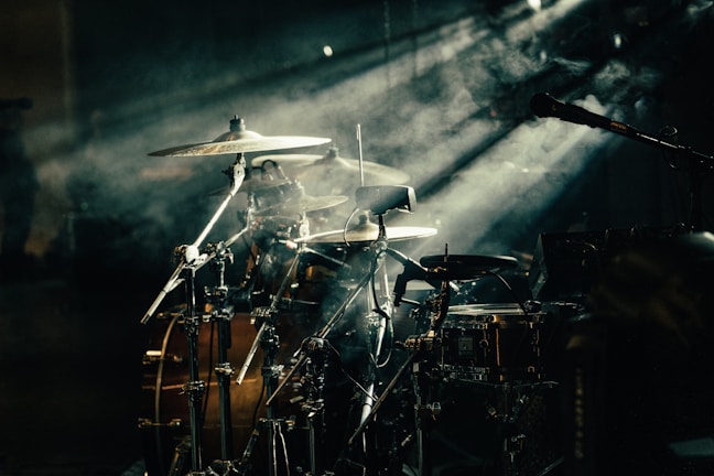Dynamic shot of the full drum kit surrounded by fog and colored lights.