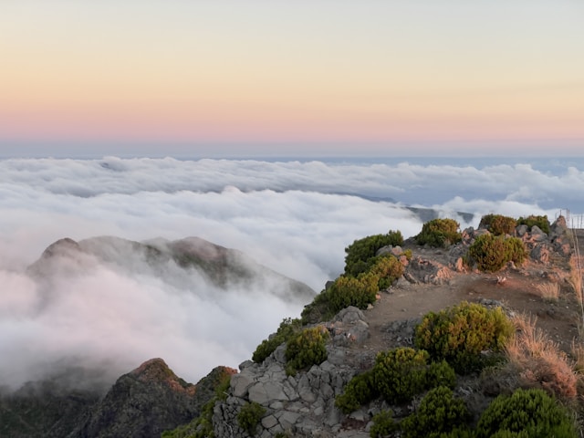 a view of a mountain with a bridge above the clouds
