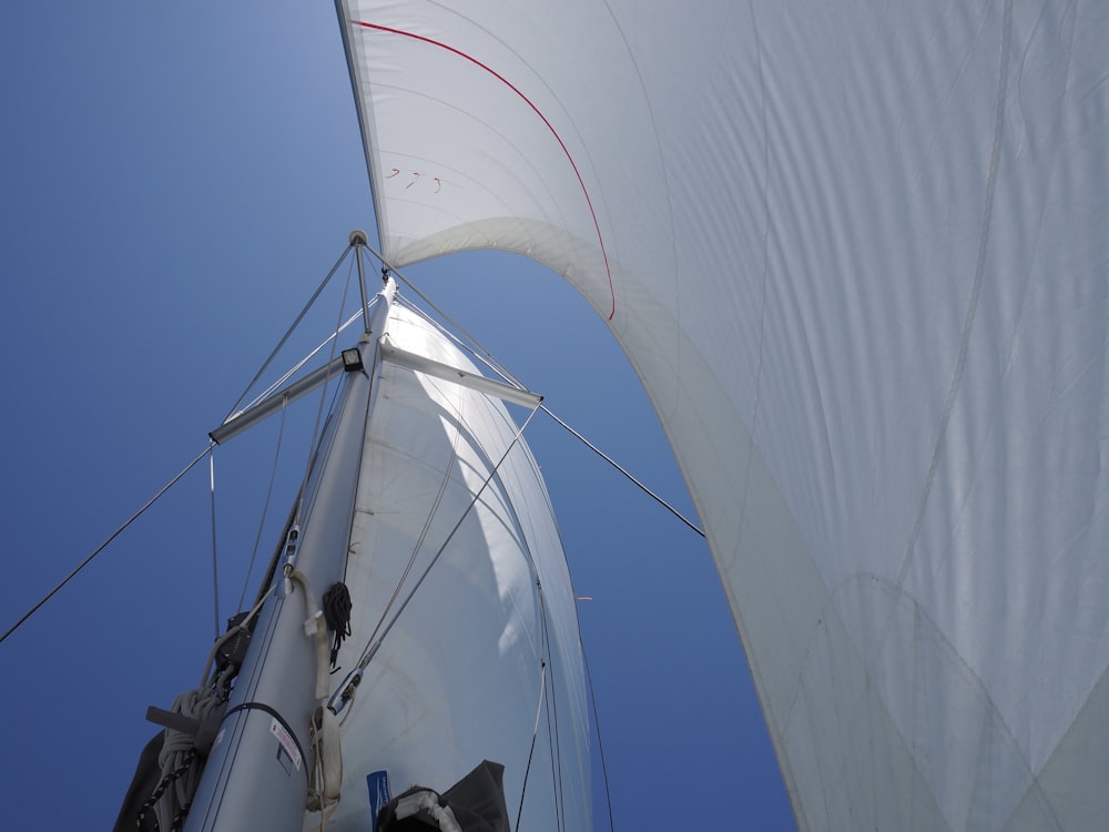 a white sail boat with a blue sky in the background