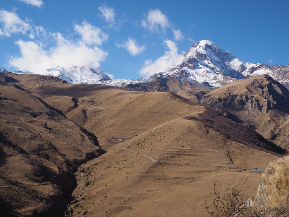 a view of a mountain range with snow capped mountains in the background