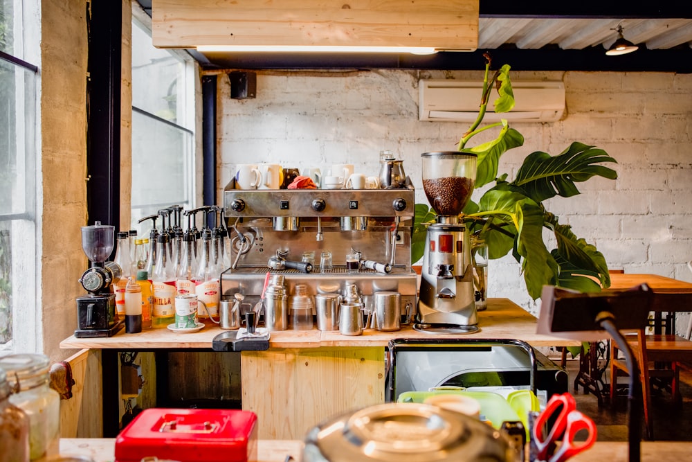 a kitchen filled with lots of clutter and a potted plant