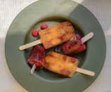 Top view of fresh fruit and ingredients next to freshly made geladinho popsicles.