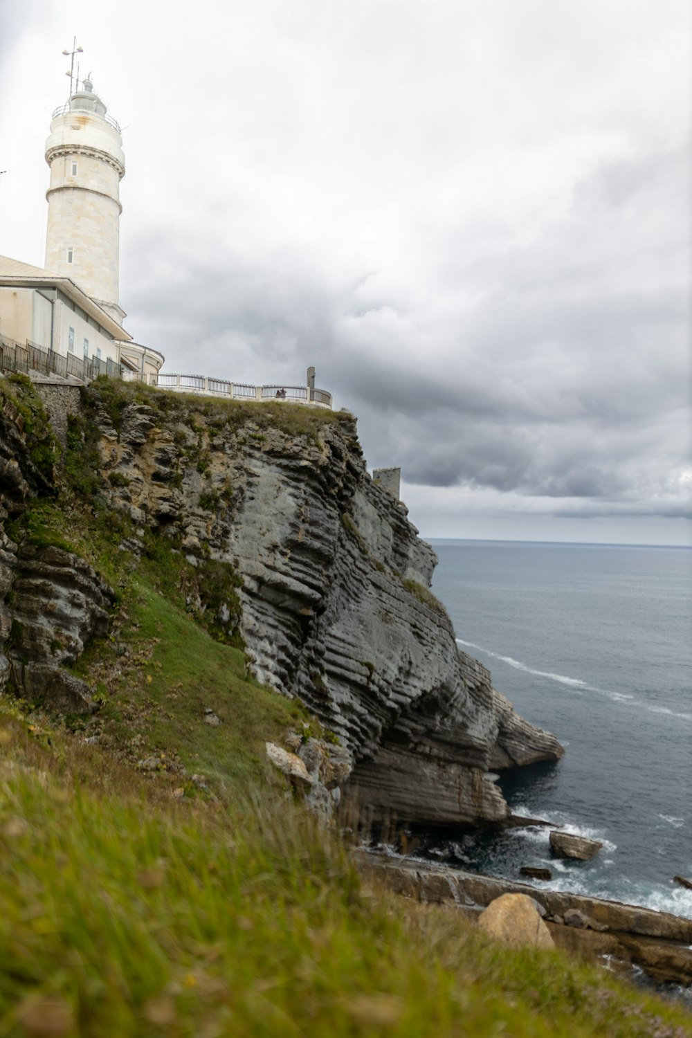 a lighthouse on a cliff overlooking the ocean