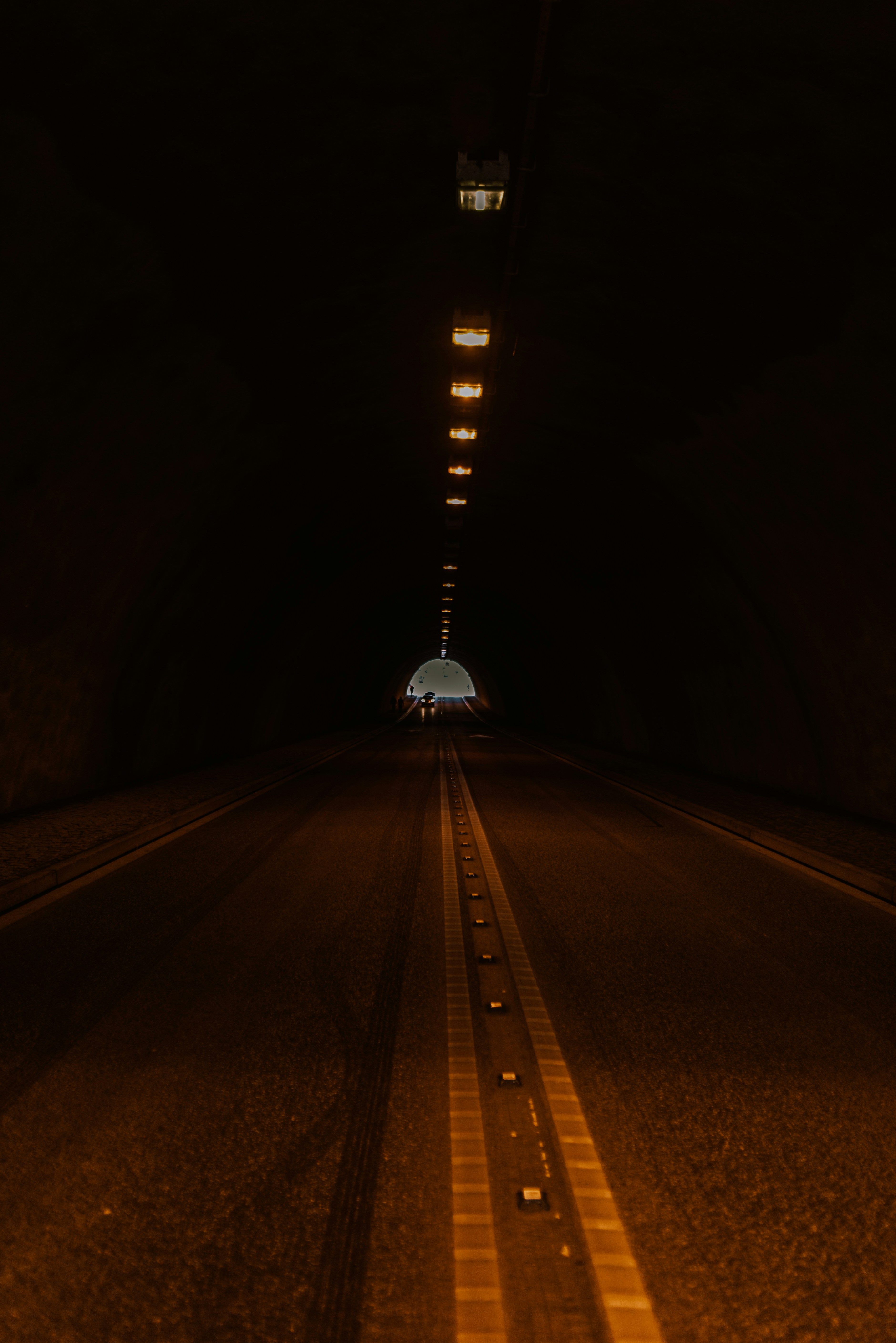 a long road with a light at the end of it