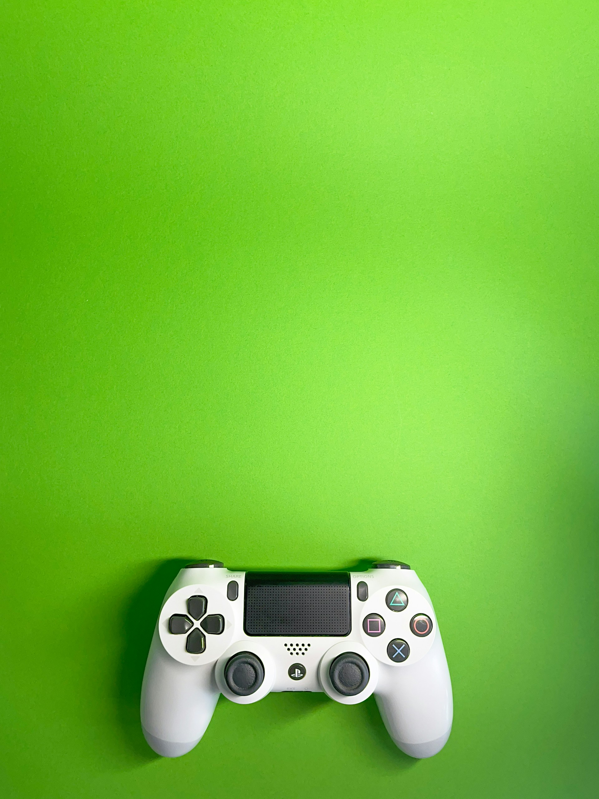 a video game controller on a green wall