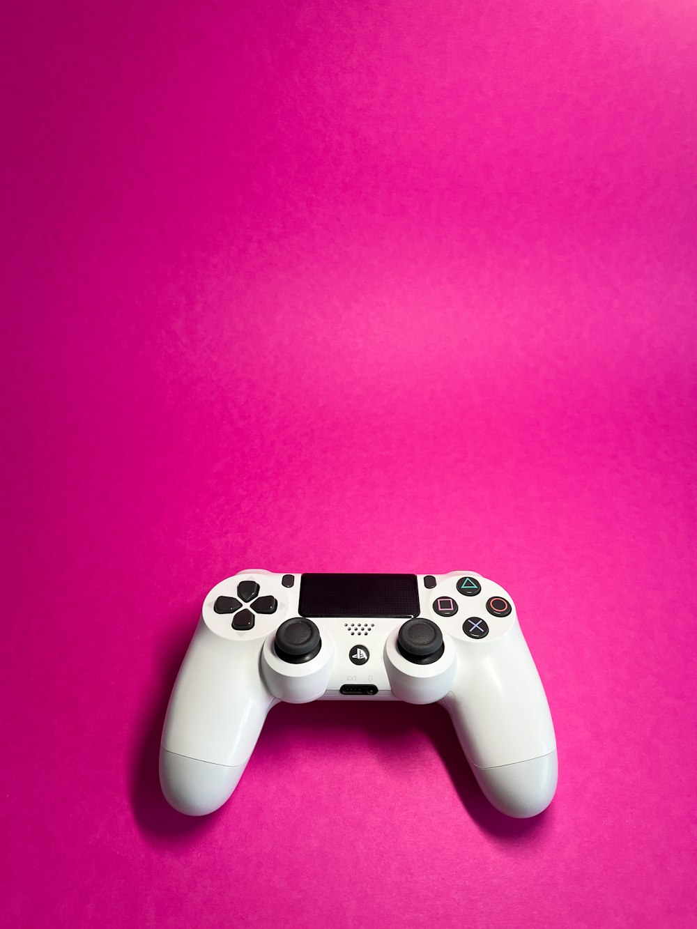 a video game controller on a pink background